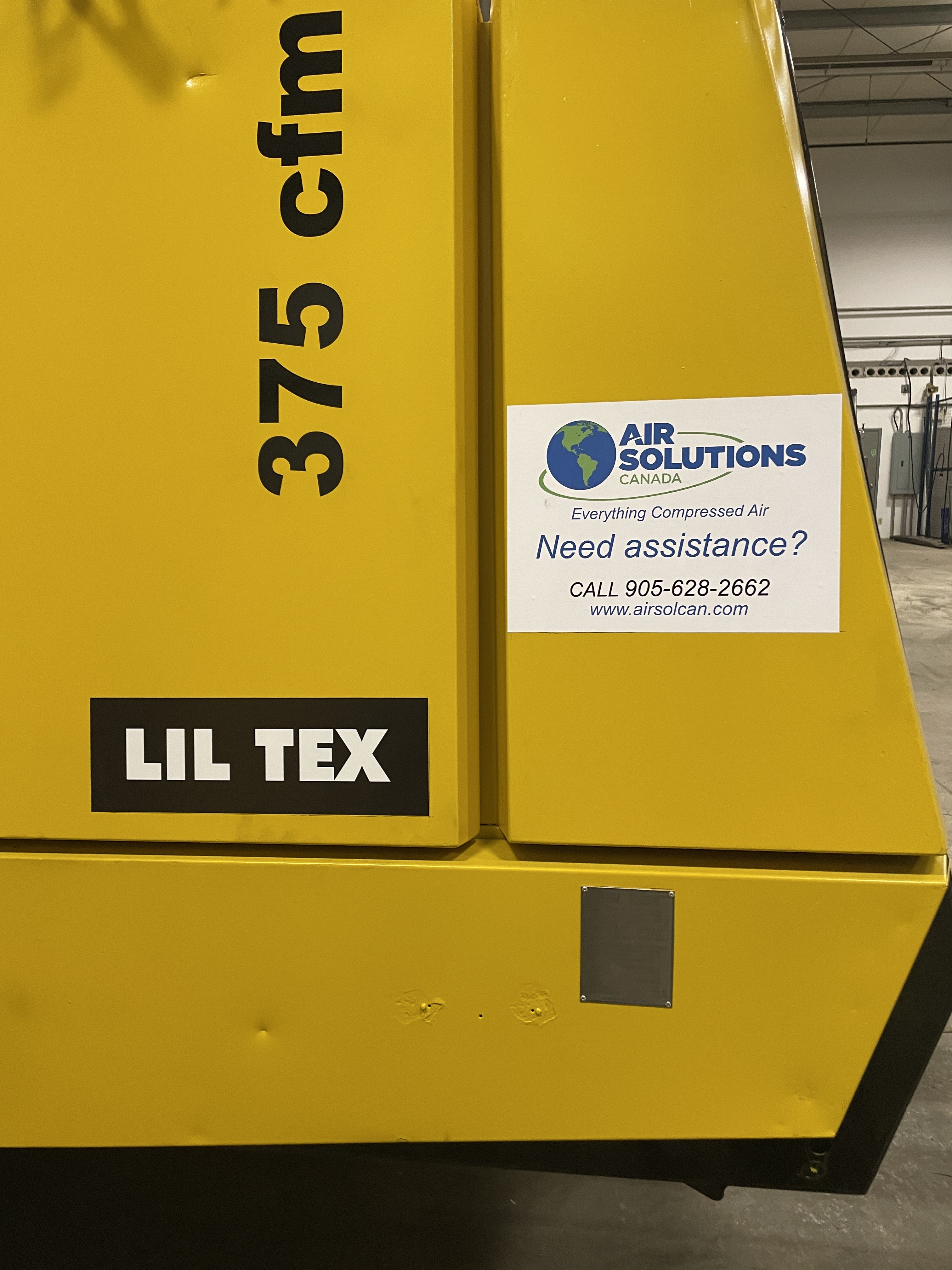 Yellow industrial equipment labeled “LIL TEX 375 cfm” with an Air Solutions Canada assistance sticker showing contact information.
